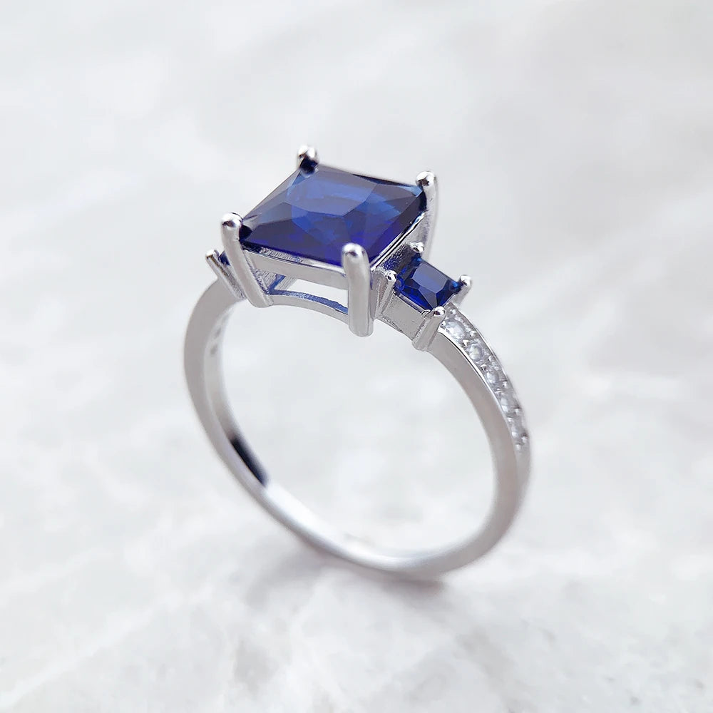 Silberner Ring mit großem quadratischem blauem Stein und kleinen blauen Akzenten