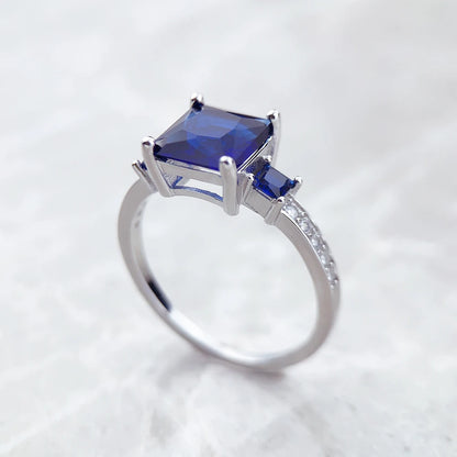 Silberner Ring mit großem quadratischem blauem Stein und kleinen blauen Akzenten