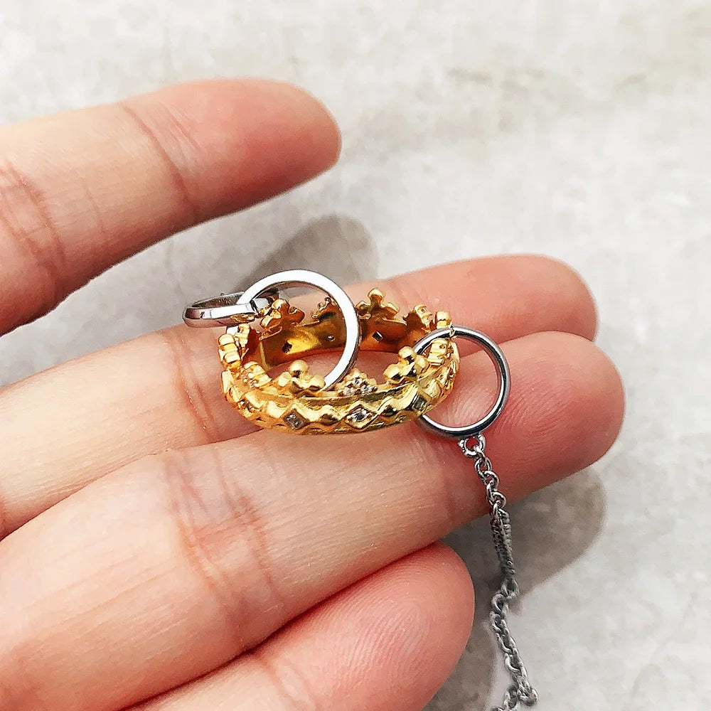 Halsketten-Anhänger in Gold und Silber in der Hand gehalten