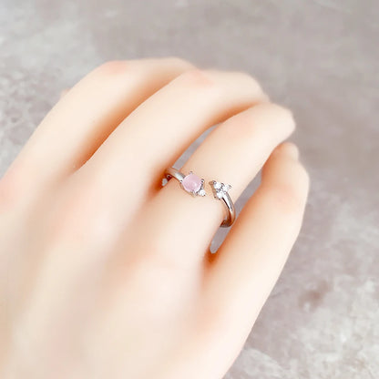 Ring am Finger: rosafarbener Stein mit funkelnden Zirkonia neben der Fassung
