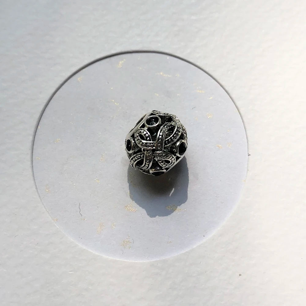 Schwarzer Liebesknoten-Charme mit filigranen Ornamenten in Sterlingsilber