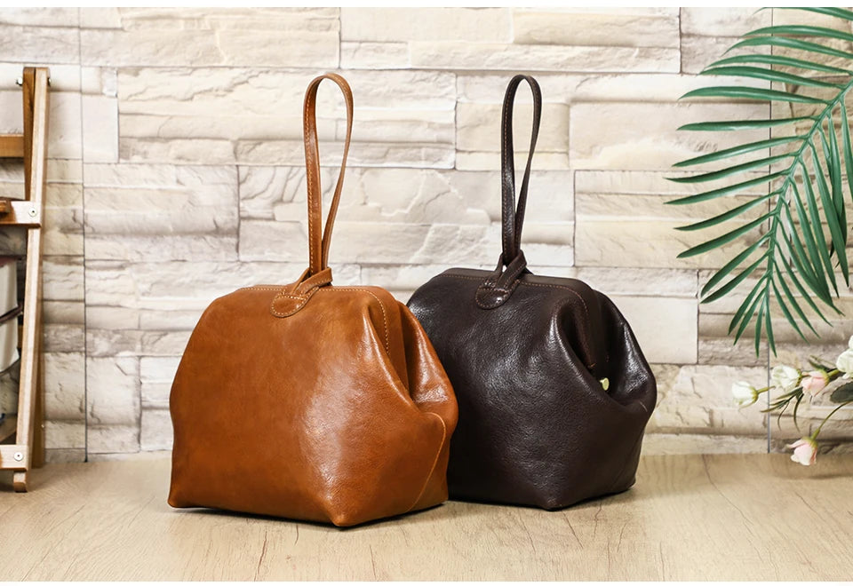 Kleine Handtaschen aus Leder, Cognac- und Dunkelbraun, jeweils mit Henkel