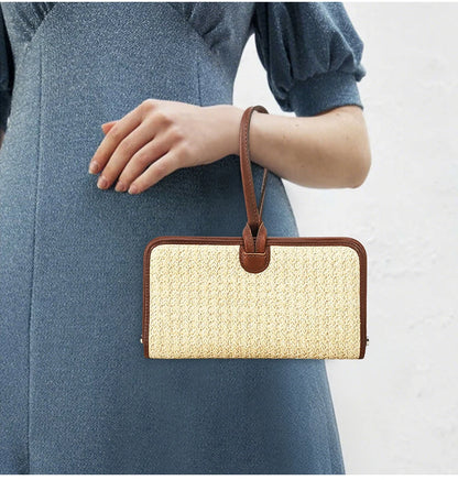 Beige Stroh-Handytasche mit braunem Lederrahmen und Handgelenkschlaufe am Arm