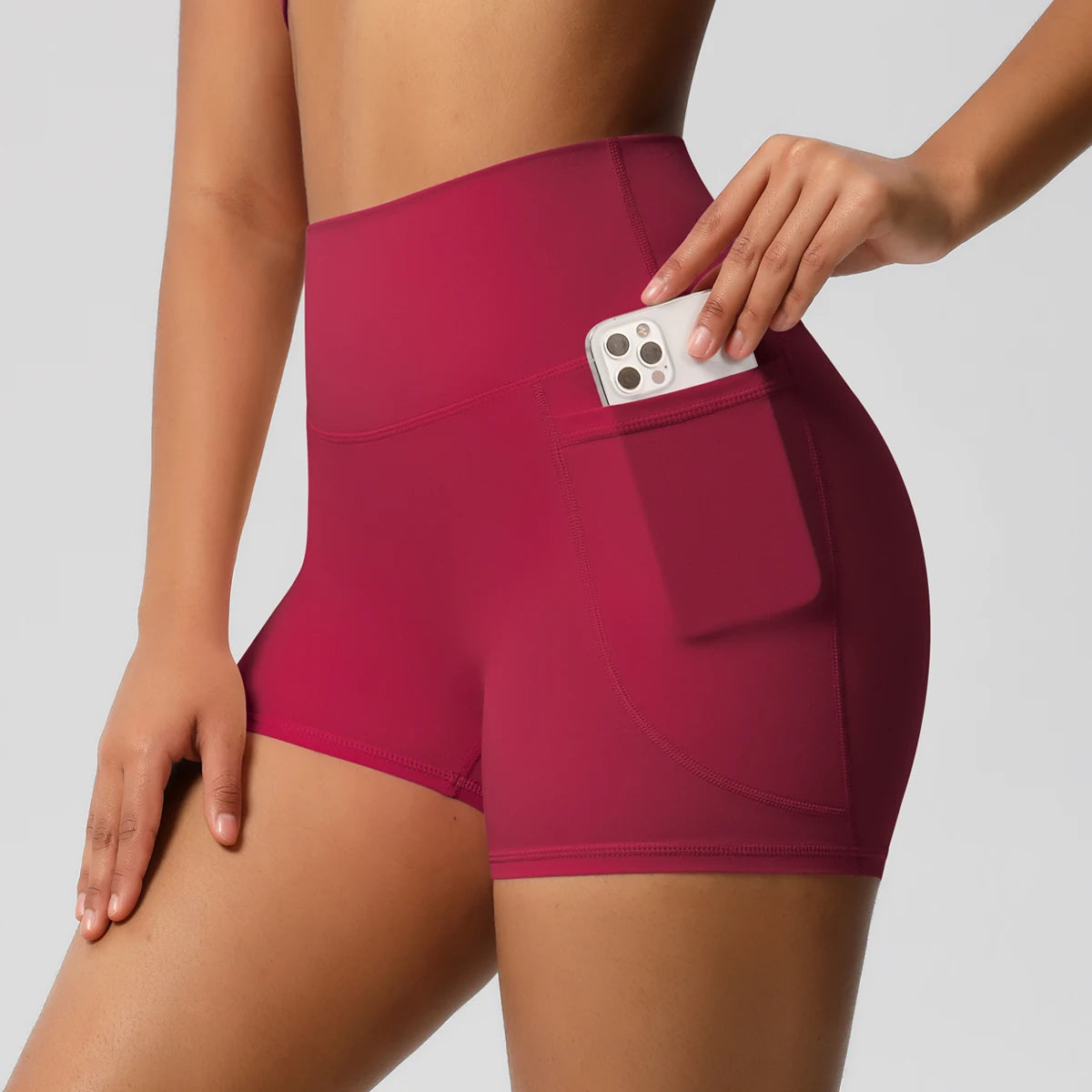 Damen-Yogashorts hohe Taille mit Seitentaschen, bordeauxrot, mit eingestecktem Handy