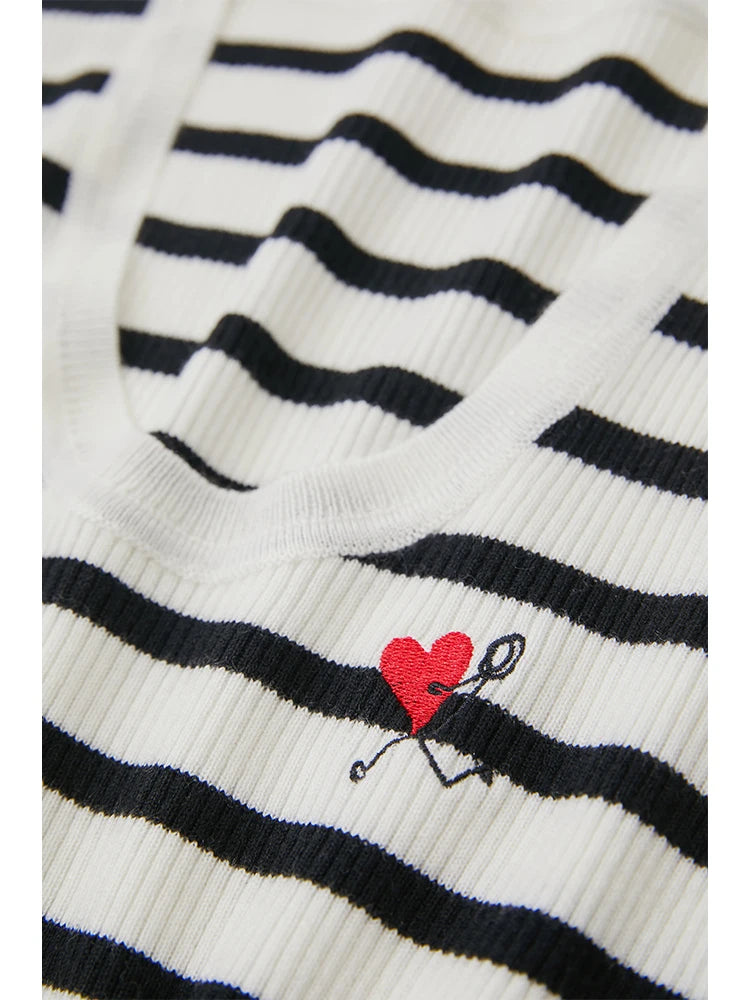 Nahaufnahme: gestreifter Strickpullover mit rotem Herz-Logo auf der Brust