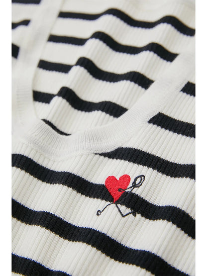 Nahaufnahme: gestreifter Strickpullover mit rotem Herz-Logo auf der Brust