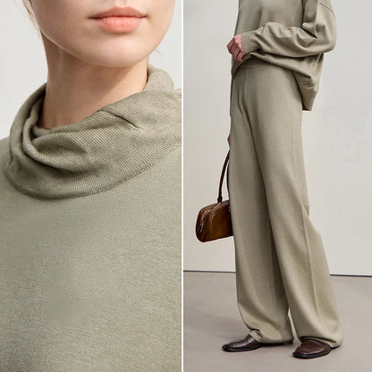 Nahaufnahme: beiger Rollkragenpullover-Strick und weite Hose, braune Umhängetasche