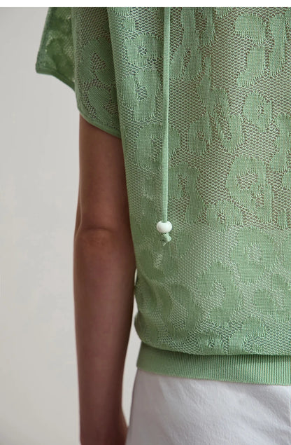 Nahaufnahme: hellgrünes Jacquardmuster am Kurzarm-T-Shirt, mit Zierknopf