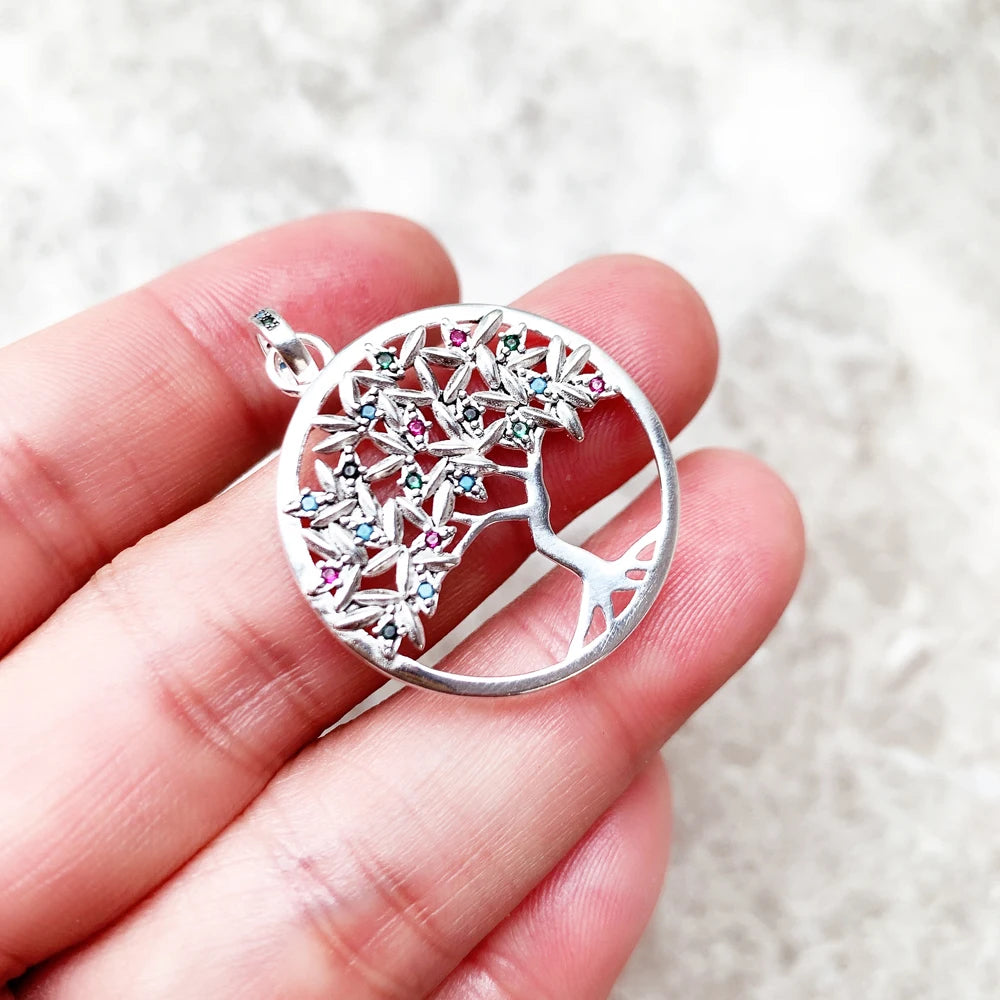 Baum-Anhänger aus Sterlingsilber mit funkelndem Steinbesatz, Nahaufnahme am Finger