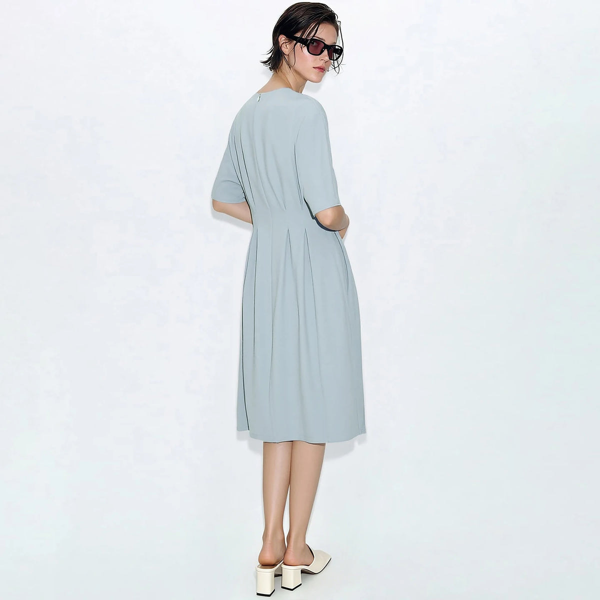 Tailliertes Midi-Kleid in hellem Blau, Seitenansicht mit kurzem Ärmel und Falten am Bund