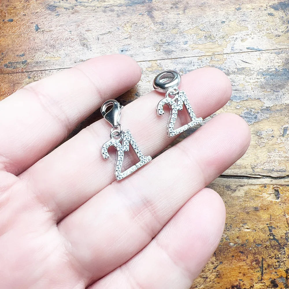 Charms-Anhänger „21“ aus 925er Sterlingsilber, auf der Hand gehalten, Detail der Öse