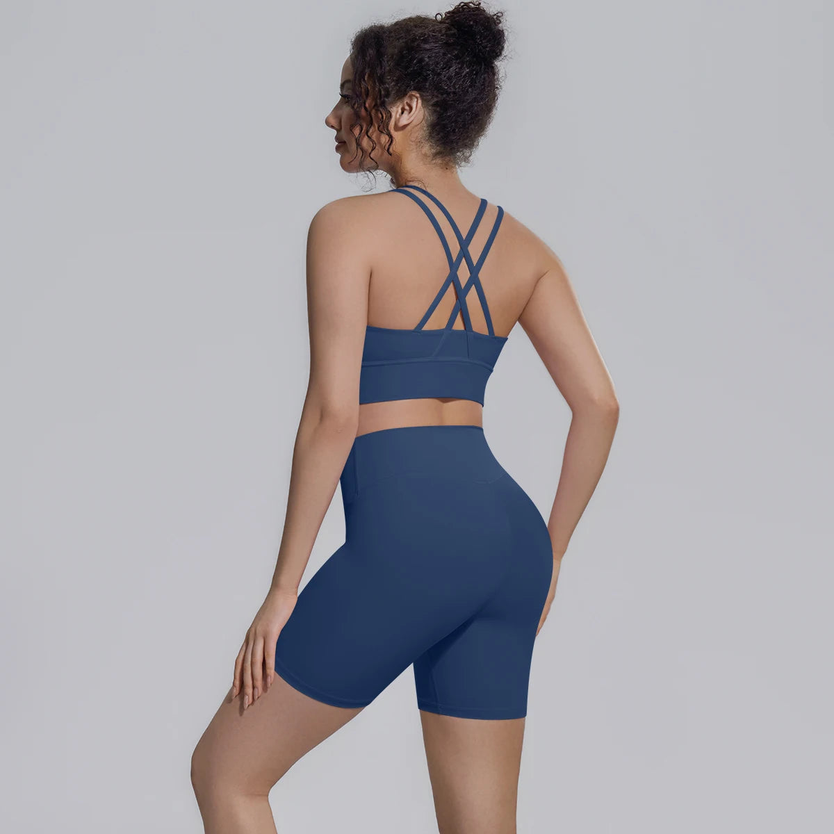 Dunkelblaues Yoga-Set von hinten: Sporttop mit gekreuzten Trägern und Shorts