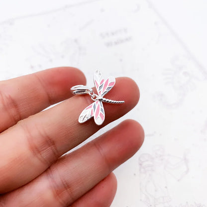Schmetterling-Schmuckanhänger aus 925 Sterlingsilber in der Hand mit rosa Emaille