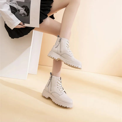 Beige Stiefeletten mit Schnürung, doppelten Reißverschlüssen und dicker Profilsohle.