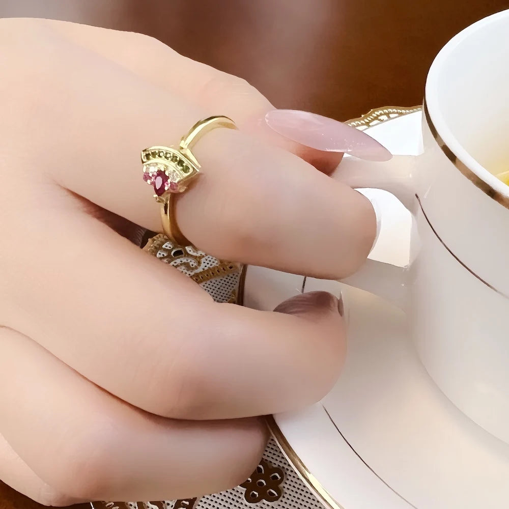 Goldfarbener Ring aus 925er Sterlingsilber mit pinkem Stein und grüner Besatzung