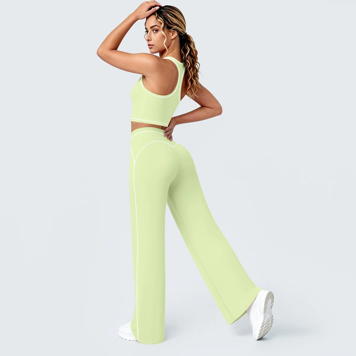 Damen-Yoga-Set in Hellgrün: Racerback-Top mit kontrastierenden Linien, weite Hose mit Nahtkanten.