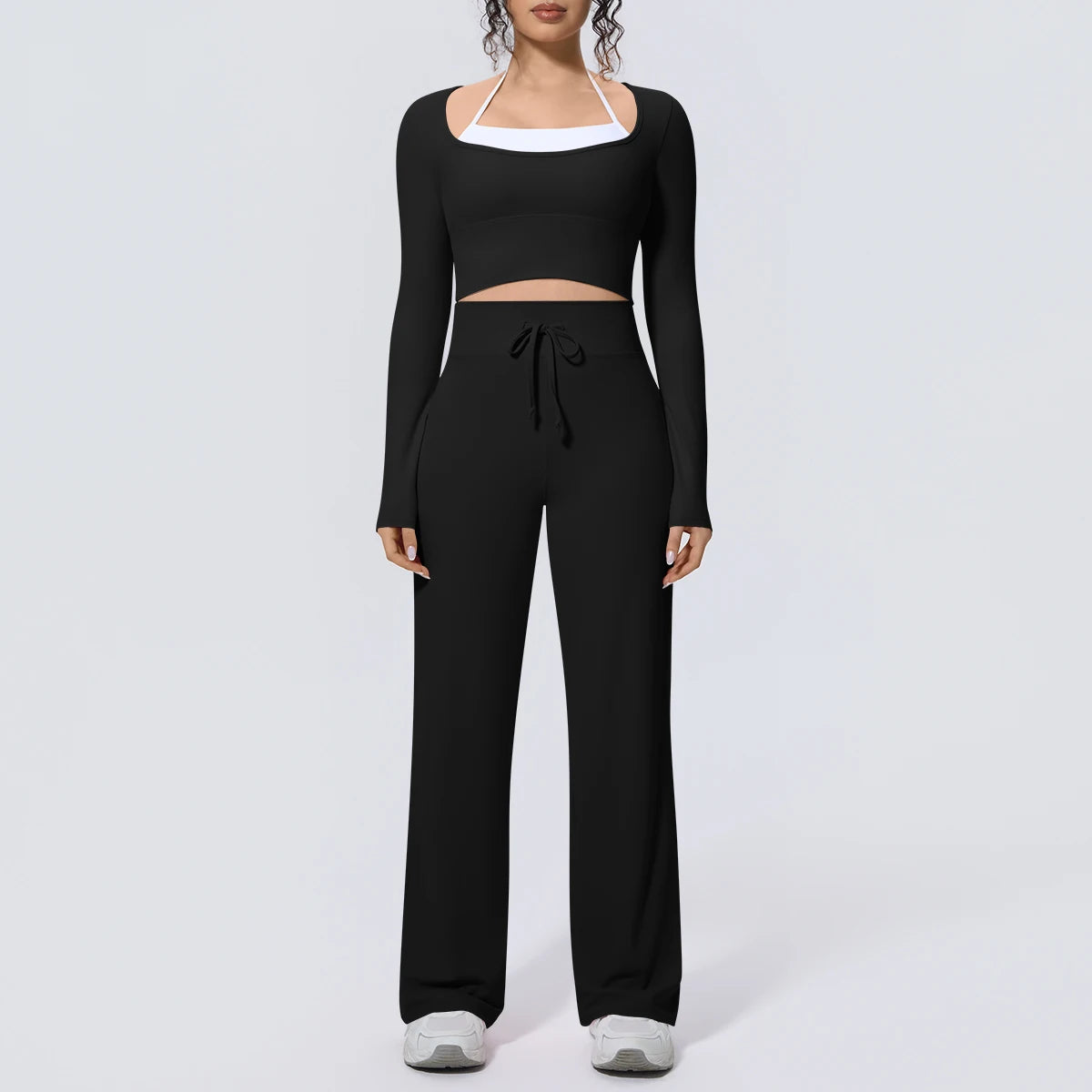 Schwarzes Yoga-Set: langärmeliges Crop-Top mit weißem Ausschnittband und weiter Hose