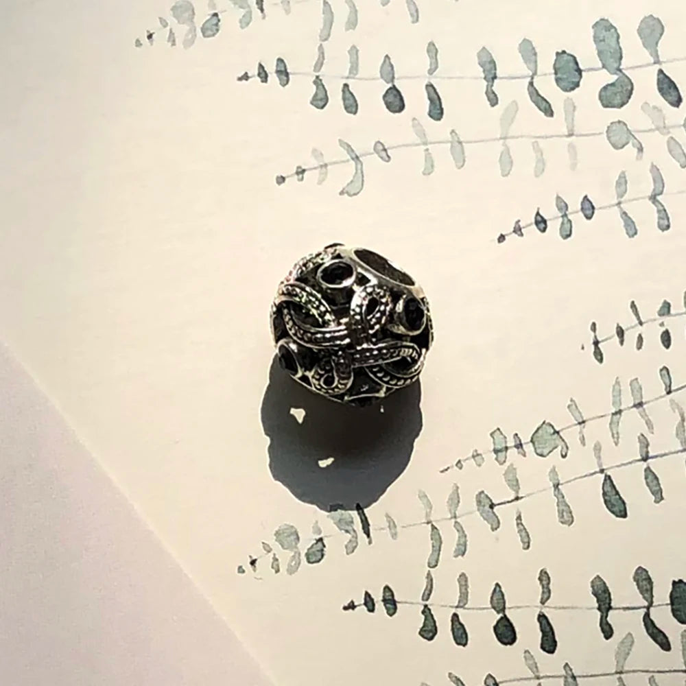 Liebesknoten-Charme aus Sterlingsilber mit dunklen Einsätzen und Ornamente