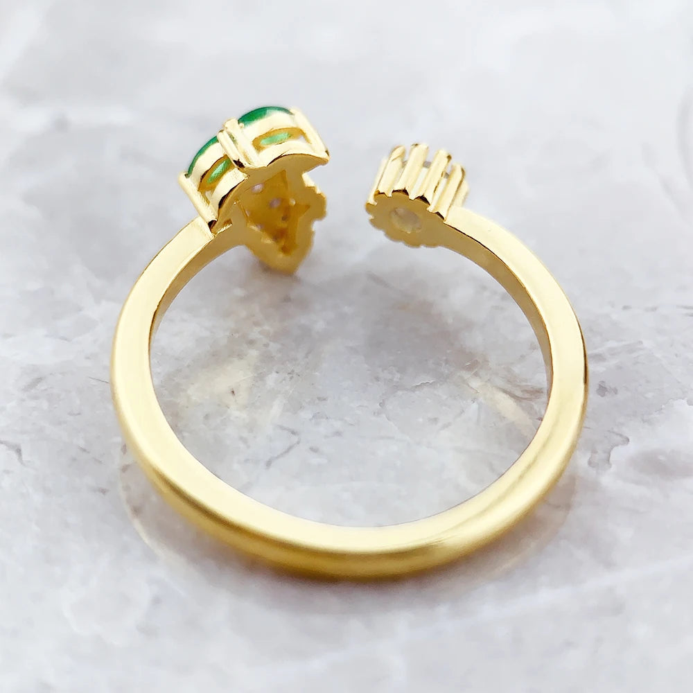 Ring-Ansicht von oben: goldfarbene Fassung mit grünem Stein und Zacken