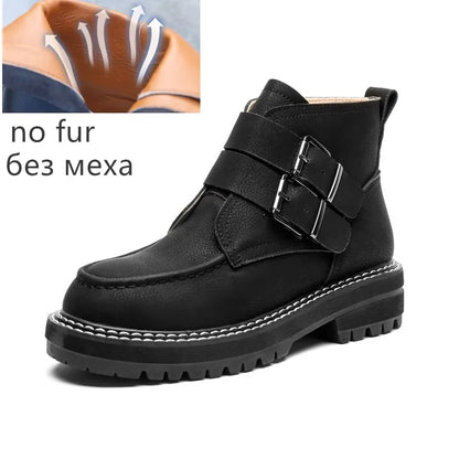 Schwarze Kurzstiefel ohne Fell, Riemen mit Metallschnalle, Profilsohle.