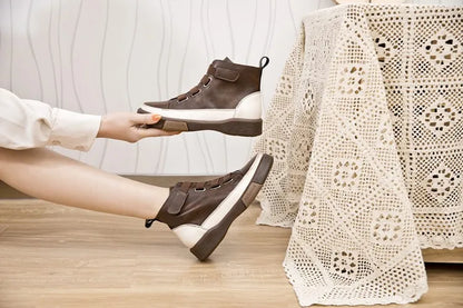 Winterstiefeletten mit Schnürung, braunes Obermaterial, dunkle Laufsohle und weißer Seitenakzent