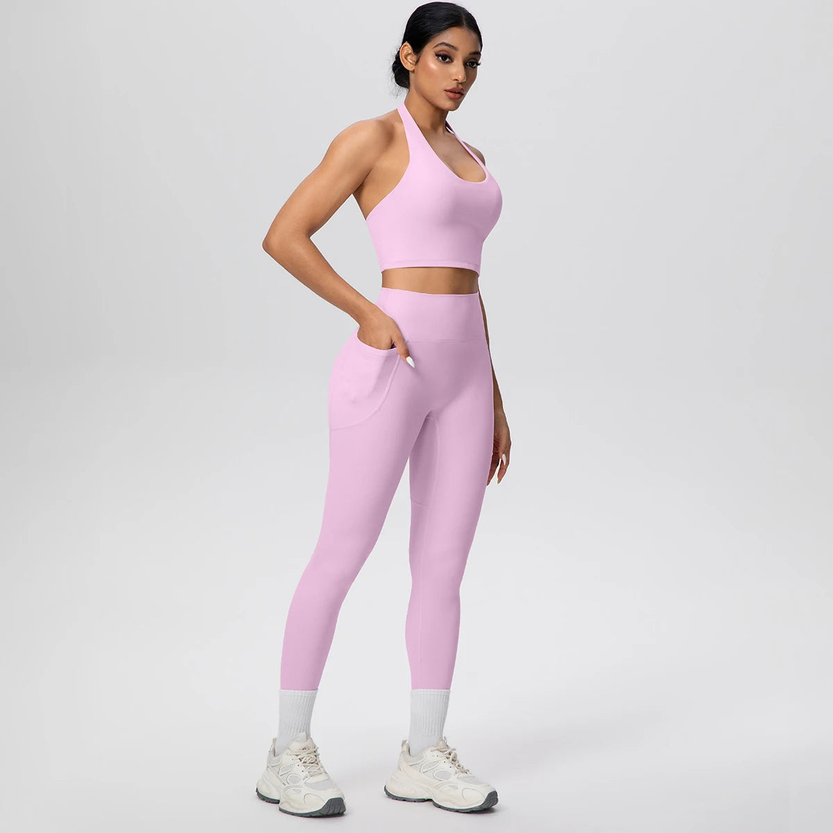 Lila Yogaset für Frauen: Sport-BH und lange Leggings, Seitenansicht mit Händen an der Taille