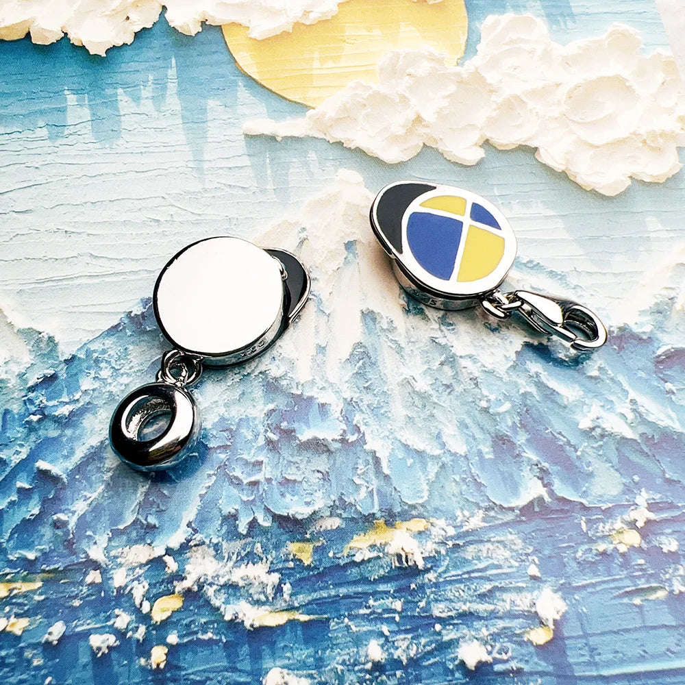 Paar-Charms aus Silber: runder weißer Einsatz und schicker blau-gelber Detail-Charm