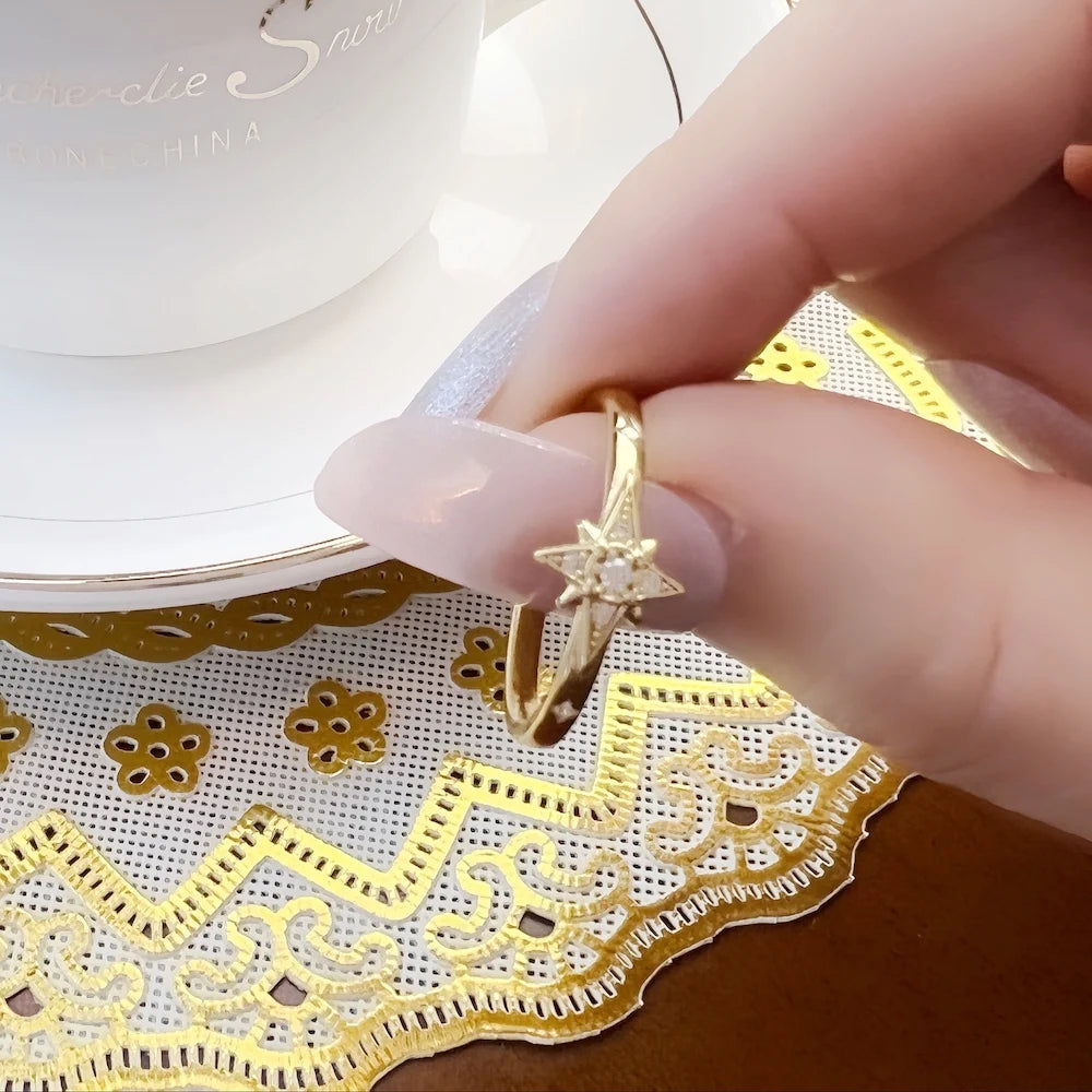 Goldfarbener Sternring mit Mittelstern, Detailaufnahme am Finger