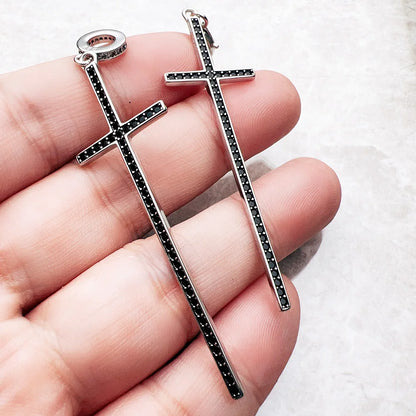 Kreuz-Anhänger aus Sterlingsilber im Handfoto, schwarze Ziersteine und Öse