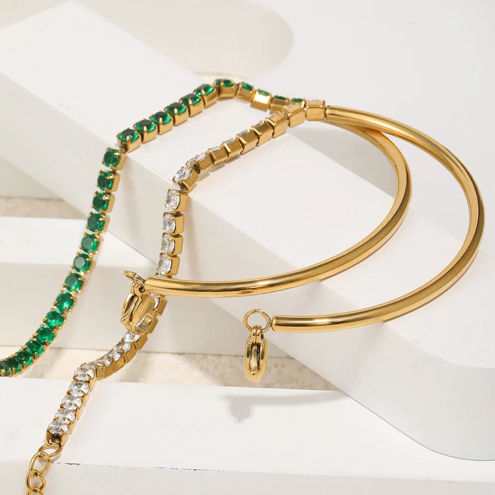 Close-up: goldfarbene Tennisarmbänder mit grünen und weißen CZ-Steinen, mehrere Verschlüsse