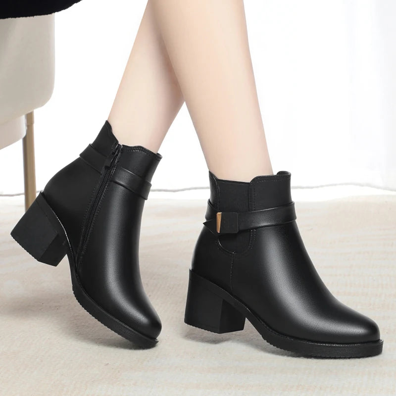 Damen-Winterstiefelette aus Leder, schwarz, breiter Riemen, Blockabsatz, Profilsohle, seitlicher Blick