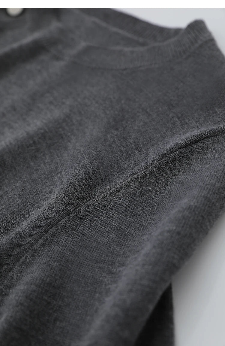 Dunkelgrauer Pullover mit feinem Strickmuster und sichtbarer Naht am Ärmel