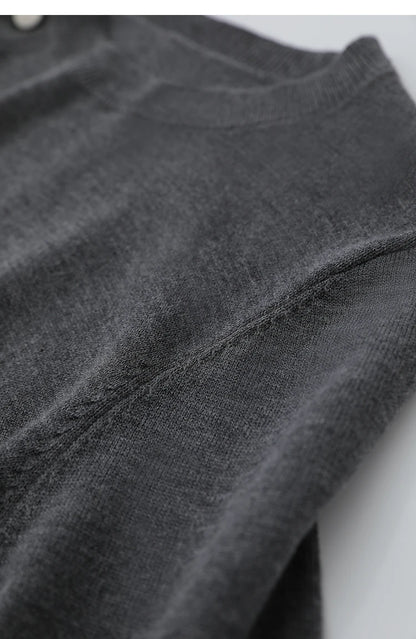 Dunkelgrauer Pullover mit feinem Strickmuster und sichtbarer Naht am Ärmel