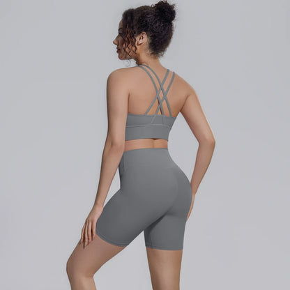 Graues Yoga-Set von hinten: Sporttop mit gekreuzten Trägern und Shorts
