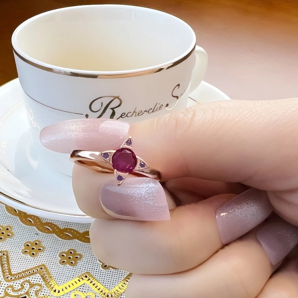 Damenring am Finger: roségoldfarbene Fassung mit violettem Stein und kleinen Akzentsteinen