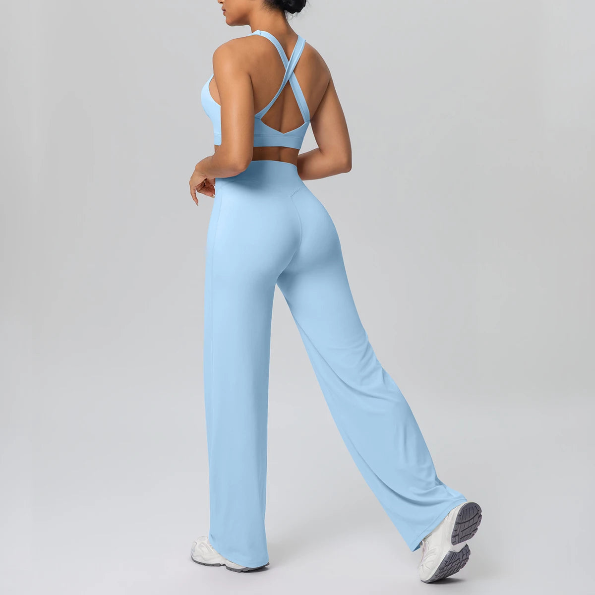 Yoga-Set mit Brustpads: hellblauer Sport-BH mit Kreuzträgern, weite Hose