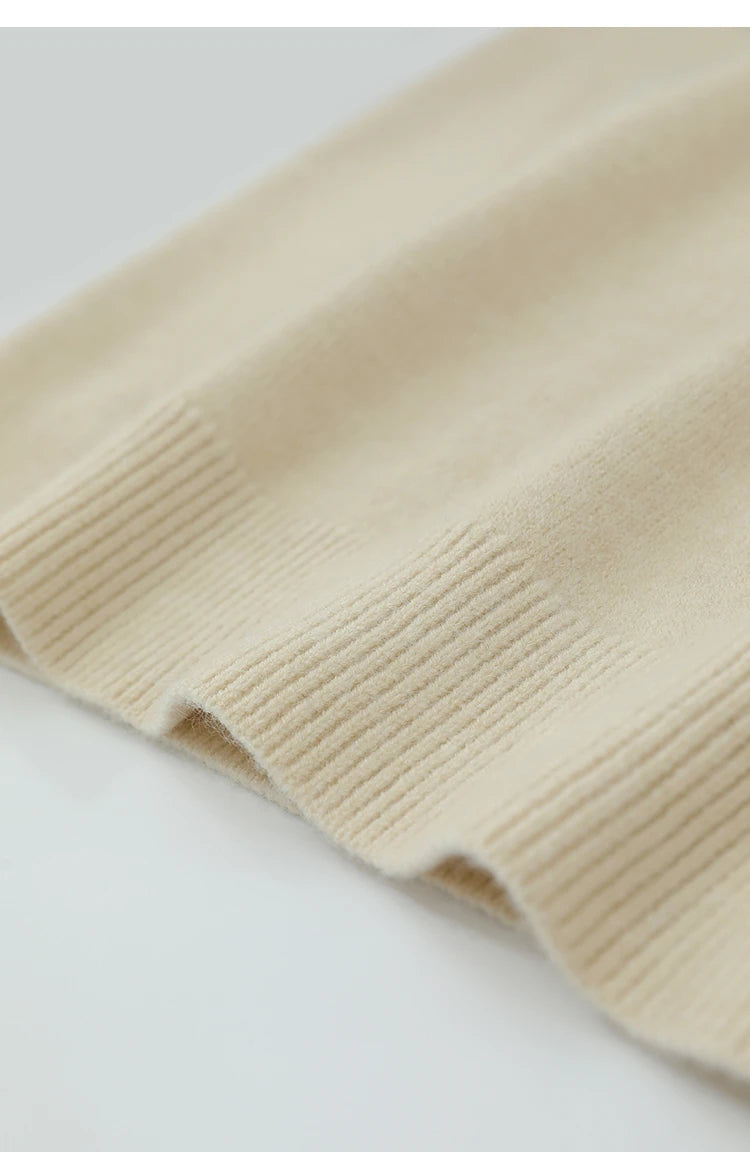 Nahaufnahme Ärmelbund: cremefarbener Strickpullover mit geripptem Saum