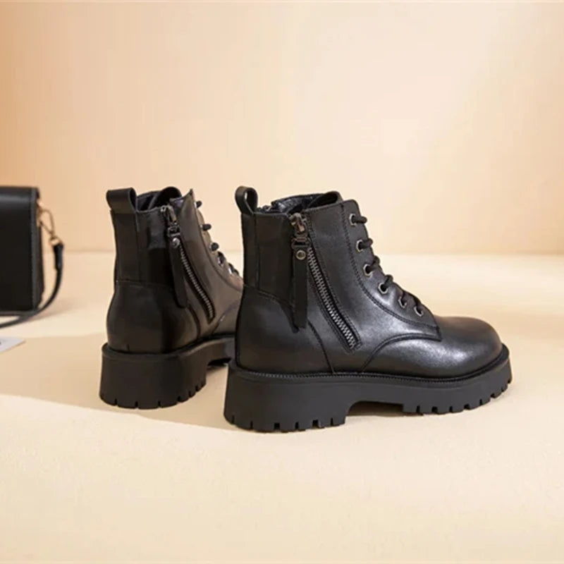 Schwarze Stiefeletten-Paar mit Schnürung, seitlichem Reißverschluss und hohem Profil