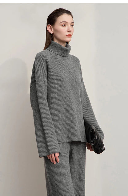 Grauer Rollkragenpullover mit langer Passform, dazu graue weite Hose