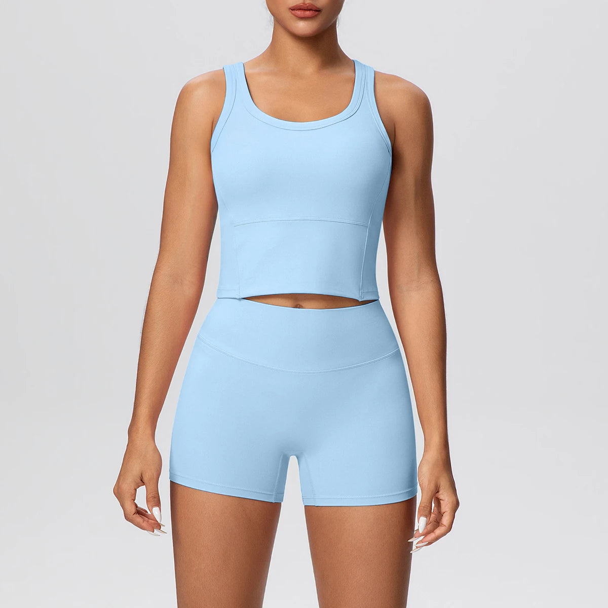Damen-Yoga-Set in Hellblau: frontales Set aus Croptop ohne Ärmel und kurzen Shorts.