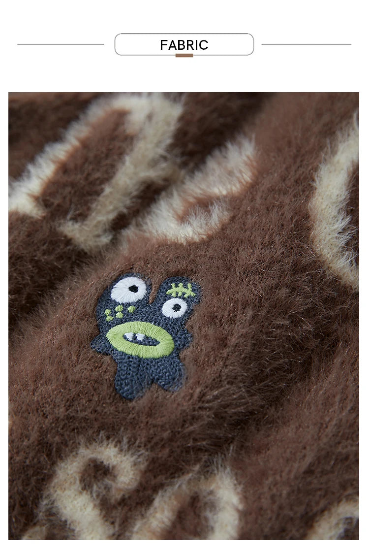 Braunes Strickdetail mit Cartoon-Monsterapplikation