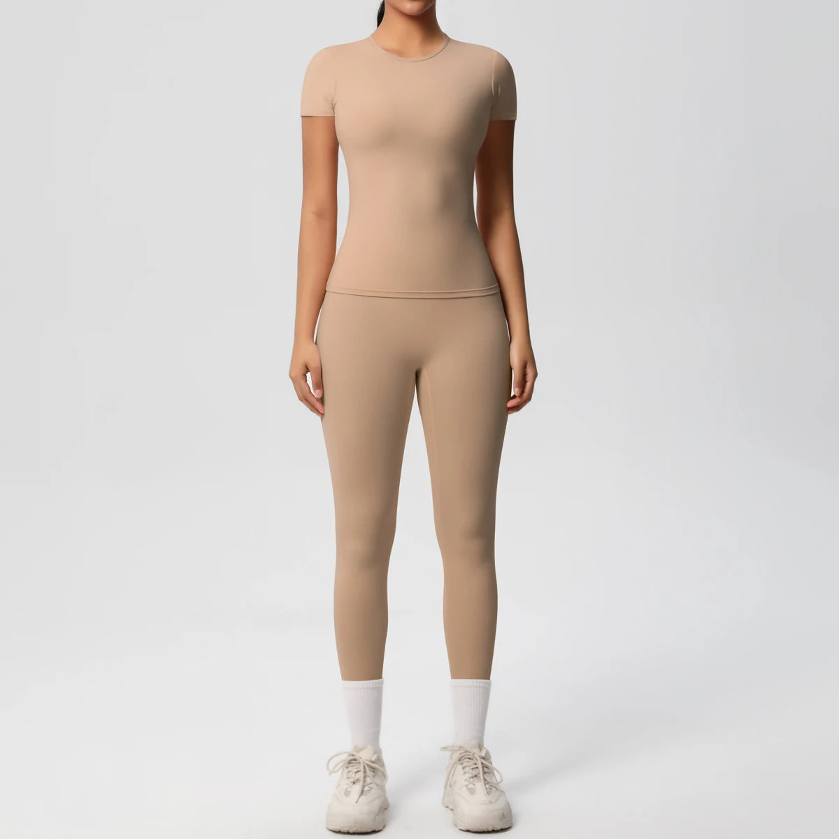 Beiges Sport-Set mit Crop-Top und Leggings im Slim-Fit, 3/4-Länge, weißer Abschluss.