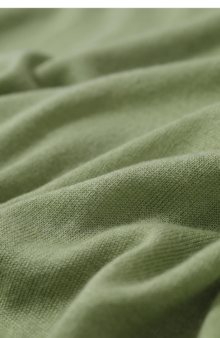 Olivgrüner Strickpullover: Detailaufnahme der Strickmaschen und weichen Stoffoberfläche
