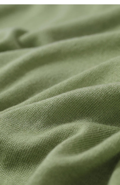 Olivgrüner Strickpullover: Detailaufnahme der Strickmaschen und weichen Stoffoberfläche
