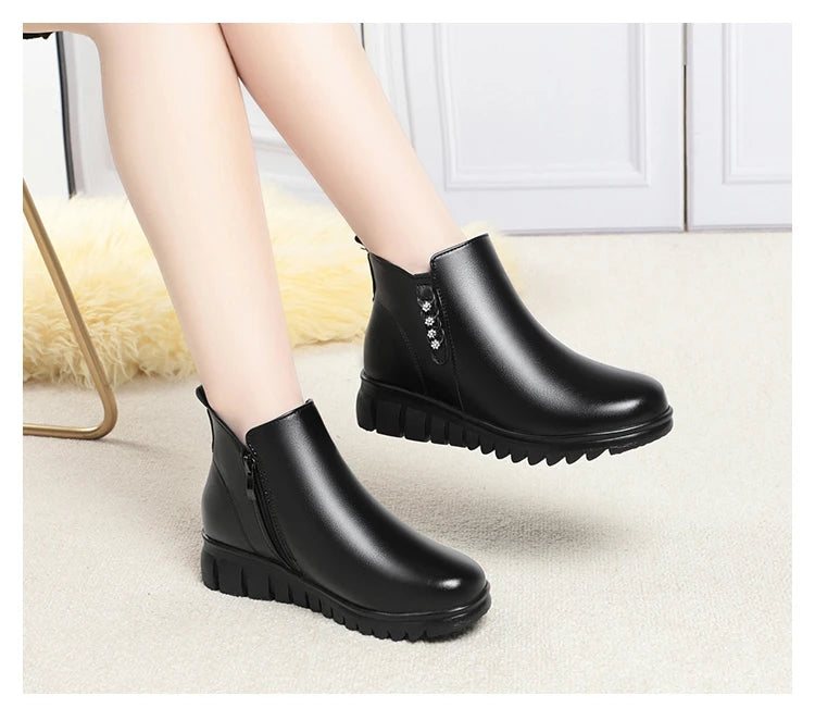Schwarze Ankle-Boots als Paar: seitlicher Zipper, gepolsterter Schaft und profilierte Sohle