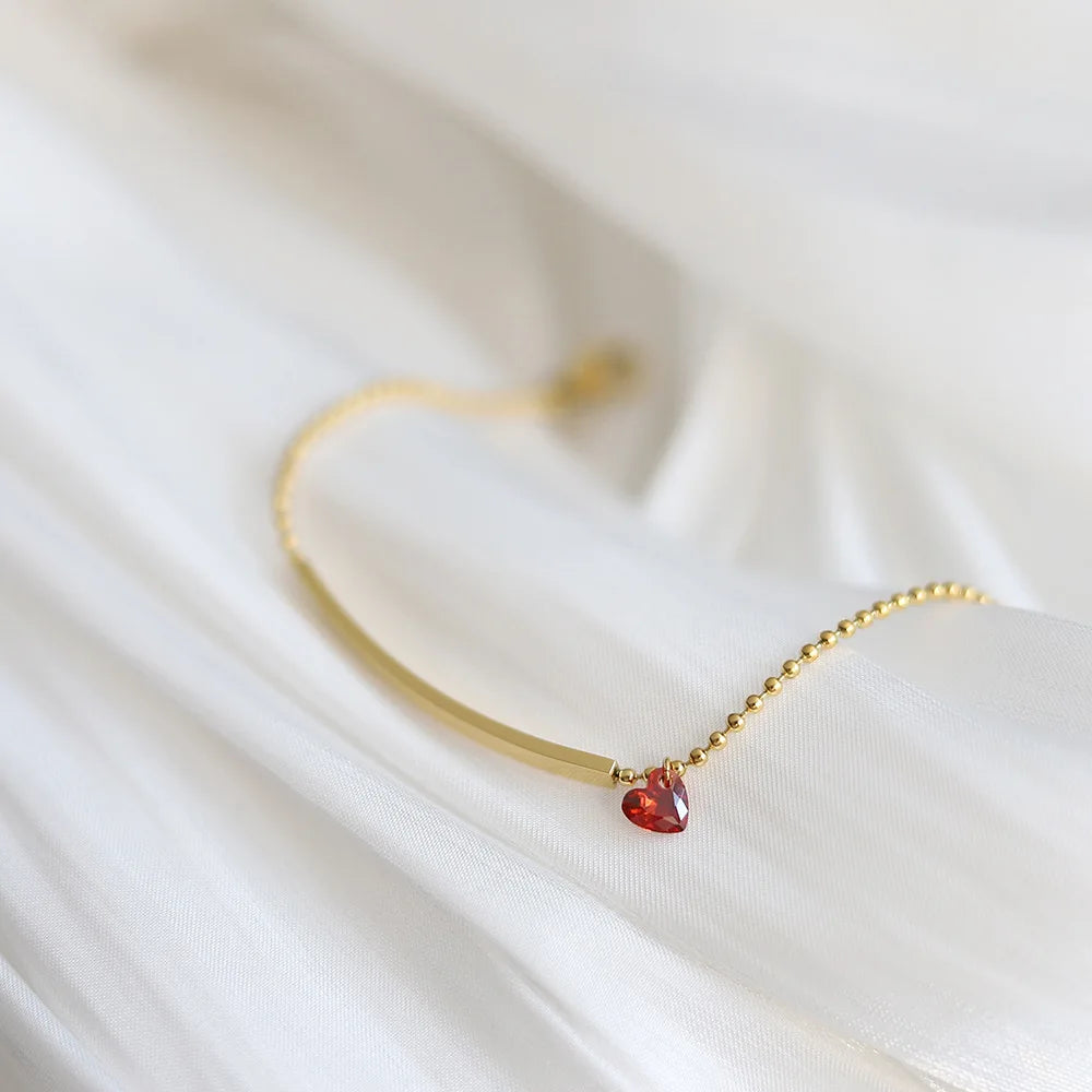 Damenarmband mit rotem Herz-Zirkonia, goldfarbenes Kettendetail und Glanzstein