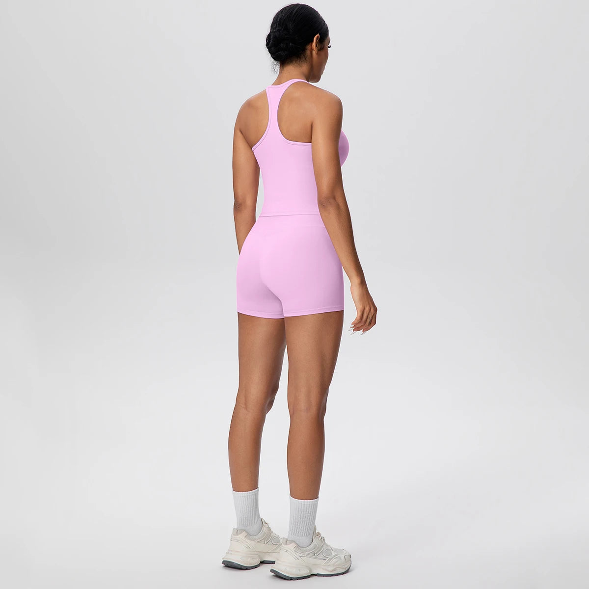 Rosa Yoga-Set von hinten: ärmellose Weste mit Trägern und High-Waist-Shorts