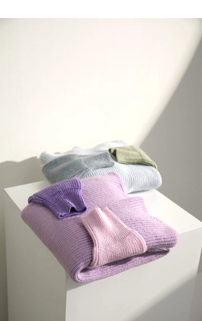 Gestapelter Strickpullover: lila, rosa und hellgrau
