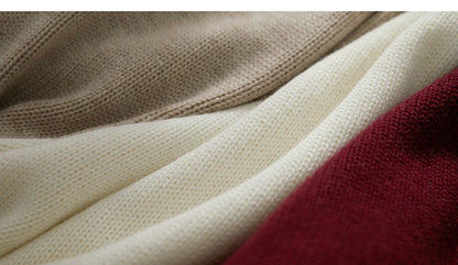 Strickstoff-Detail: beigefarbene Maschen mit weißem Rippbündchen