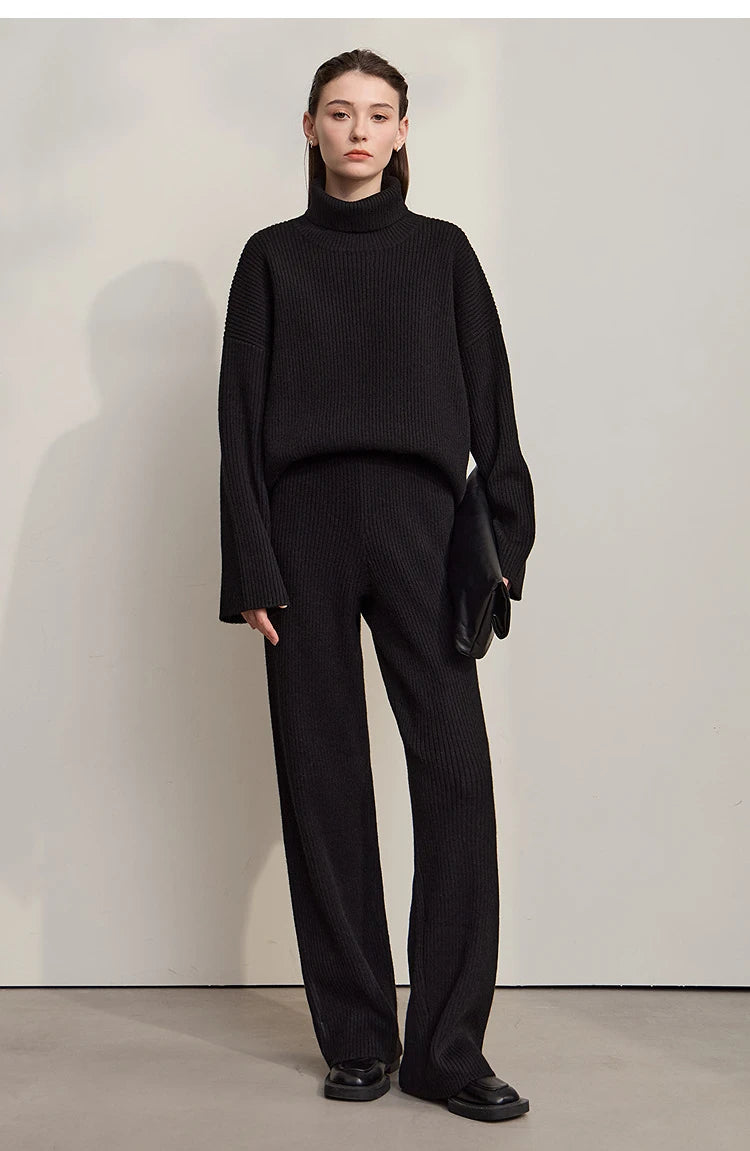 Schwarzer Rollkragenpullover mit langen Ärmeln, dazu schwarze weite Hose